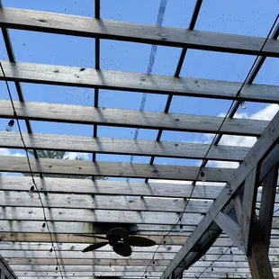 Outside patio screened in ceiling with fans.