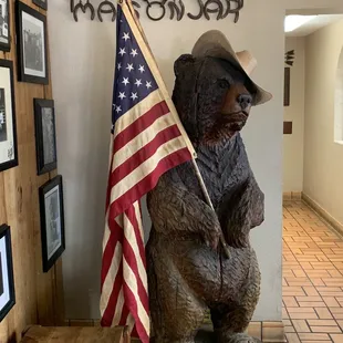 a bear holding an american flag