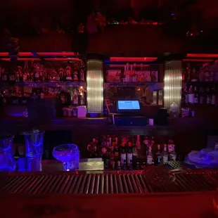 a dimly lit bar with a laptop on the counter