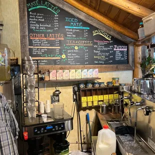 a coffee shop with a menu on the wall