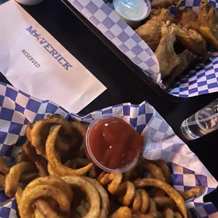 two baskets of onion rings and ketchup