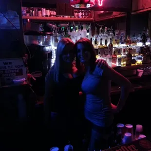 two women standing in front of a bar