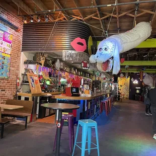 a bar with a giant elephant head hanging from the ceiling