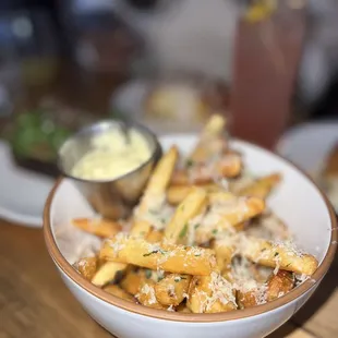 a bowl of french fries with a side of dips
