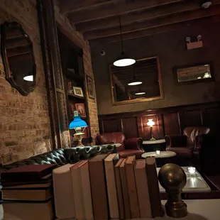 a living room with books and a lamp