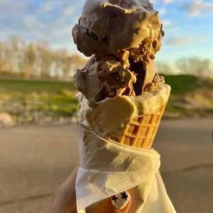 a hand holding a cone of ice cream