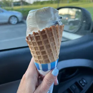 a hand holding an ice cream cone