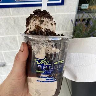 a hand holding a cup of ice cream