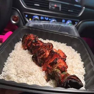 a person holding a tray of rice
