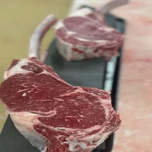 two raw steaks on a cutting board