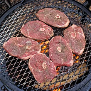 steaks cooking on a grill