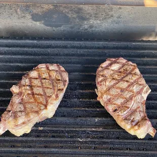 two steaks on a grill