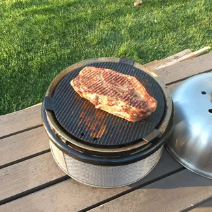 A Meat Shop steak on a Cobb Grill.