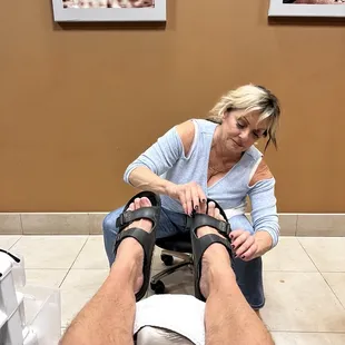 Cynthia Is putting my shoes on after a delightful pedicure!