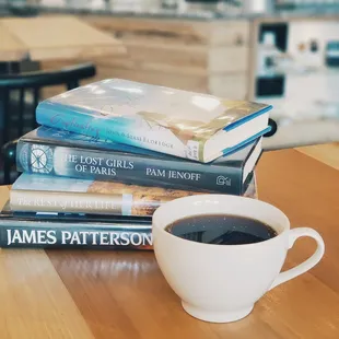 a stack of books and a cup of coffee