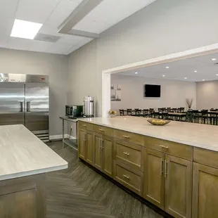Kitchen with refrigerator, freezer, microwave and coffee percolator.