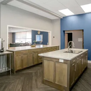 Kitchen with refrigerator, freezer, microwave and coffee percolator.