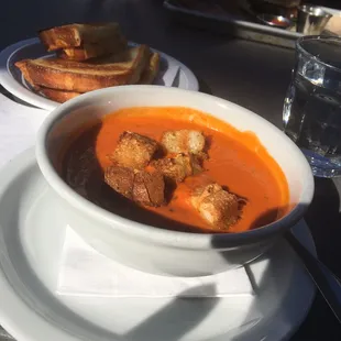 Tomato soup w/ grilled cheese sandwich in the background