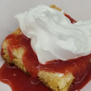 Ooey gooey butter cake topped with strawberry reduction and cool whip. Best Cake EVER!