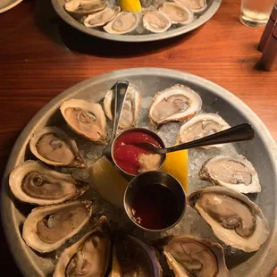 a platter of oysters with dipping sauce