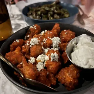 a bowl of chicken nuggies and a glass of wine