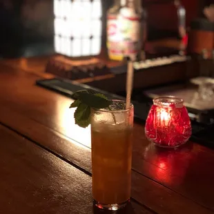 a glass of iced tea on a bar