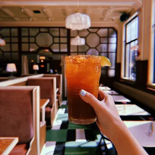 a person holding a drink in a restaurant