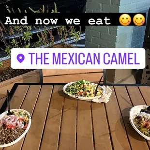 Four rice and meat bowls on an outside table at the Mexican Camel. Words say &quot;and now we eat&quot;