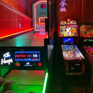 a row of pinball machines with neon lights