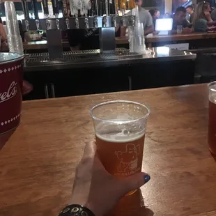 a person holding a pint of beer