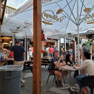 people sitting at tables under umbrellas
