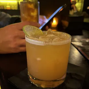 a cocktail with a lime slice on the rim