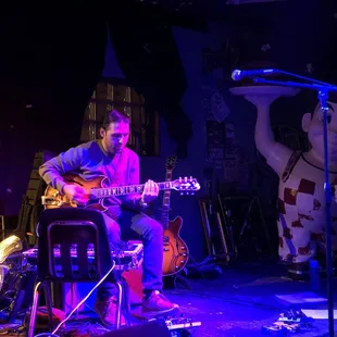 a man playing a guitar on stage