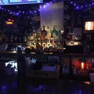 a dimly lit bar with a television in the background