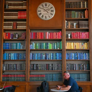 two people sitting at a table in front of a bookshelf