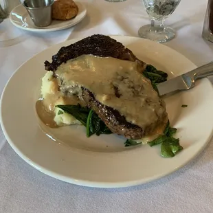 Rib eye over golden mashed potatoes and spinach. Delicious. Perfectly prepared.