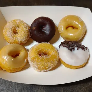Top row: Cinnamon &amp; Sugar, Chocolate Icing, Glazed.  Bottom row: Maple, Sugar-Coated, Vanilla Frosting w/Chocolate Sprinkles