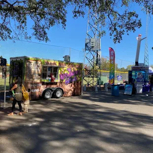 two people standing in front of a food truck