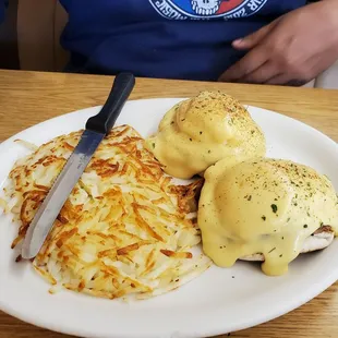 Egg and sausage Benedict with hash brown.