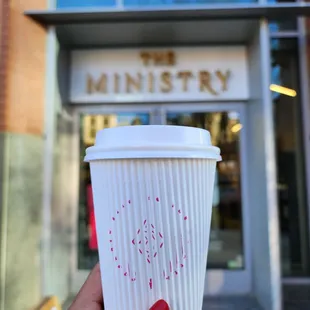 a hand holding a cup of coffee