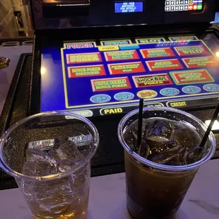 two drinks in front of a slot machine