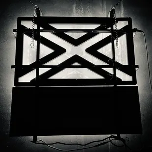 a black and white photo of a neon sign