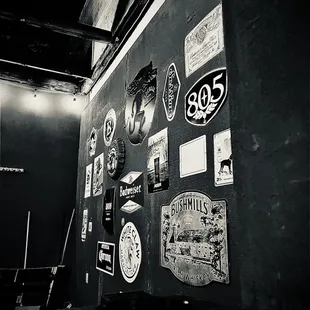 a black and white photo of a wall covered in stickers