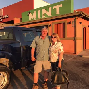 a man and a woman standing in front of a truck