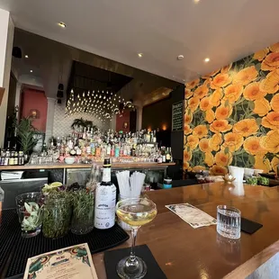 a bar with a bunch of flowers on the wall