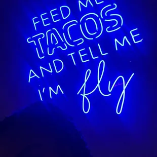 a neon sign that reads feed me, stargoose, and tell me i'm play