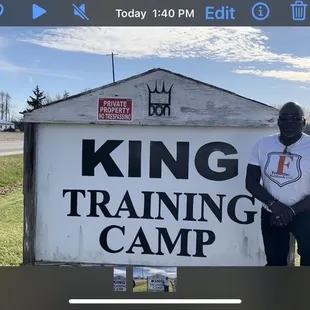 a man standing in front of a king training camp sign