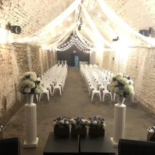 a room with white chairs and white flowers