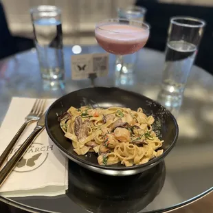 a bowl of noodles and a drink
