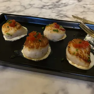 a plate of scallops on a marble table